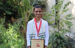 Krishna holding a medal and certificate